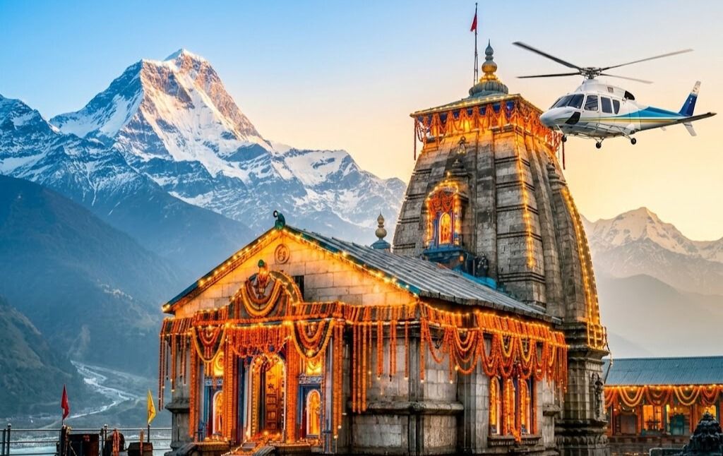  A helicopter flying over the golden Bright Kedarnath Temple with snow-capped Himalayan peaks in the background during the 2026 Chardham Yatra.